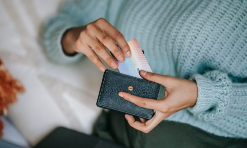 moyen de paiement : femme qui tient son porte-feuille et une carte bancaire dans ses mains