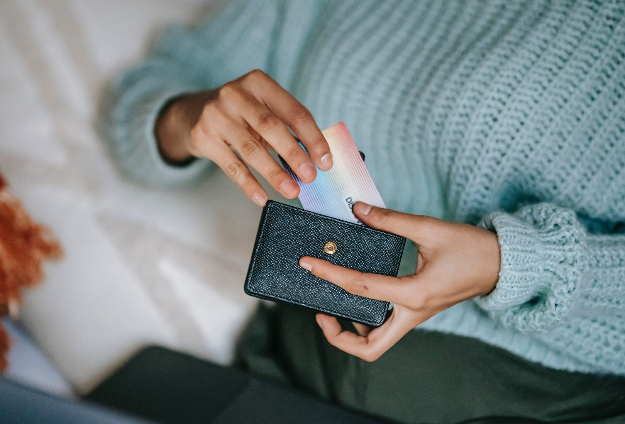 moyen de paiement : femme qui tient son porte-feuille et une carte bancaire dans ses mains